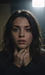 a woman with her hand on her chin looking down at the camera