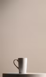 coffee cup sitting on top of a table with a brown wall