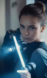 the woman is posing for the camera with her light saber