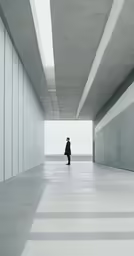 a person walking alone down a very long concrete tunnel