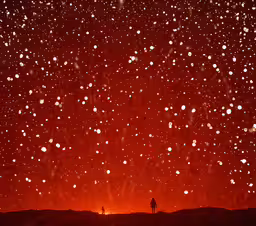 a person standing on top of a hill under a bright red sky,there is a man standing in the middle of a field