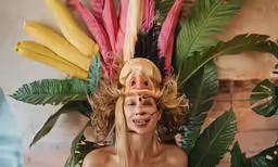a woman is posing with plants in the background