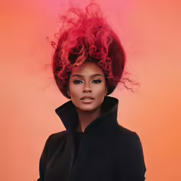 a black woman with red hair has very long, red curls on her head