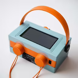 a toy radio on white background has an orange strap