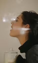 a beautiful woman looking at something that looks like smoke coming out of her mouth