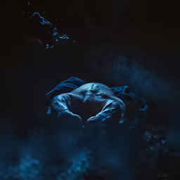 a person in the dark covered up with a blanket