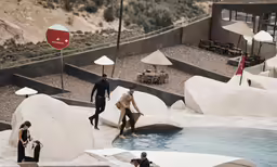 several people stand at an artificial swimming pool