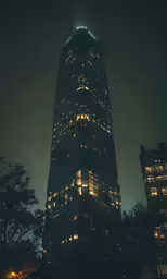 a large building at night has a tall lit up tower