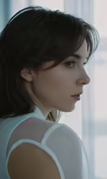 a woman in white shirt with side view of head and shoulder