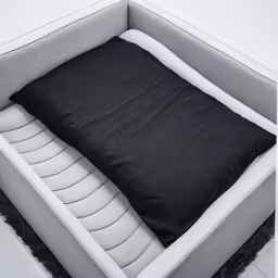 a sofa with a black cushion sits next to a white chair