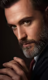 a man wearing a black suit and red tie