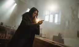 a woman is lighting candles with her hands