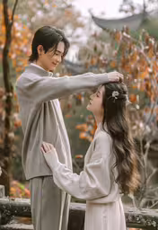 two young women in asian clothing near trees,two women that are standing in front of each other