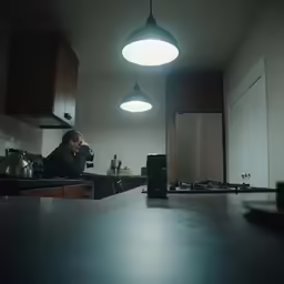 a man in a kitchen is drinking his coffee