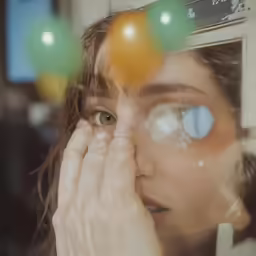 a woman looks through a mirror at some fruit