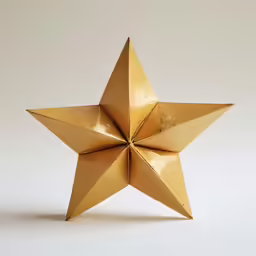 a golden gold star ornament that looks like a flower