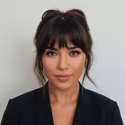 a woman with bangs wearing a black suit