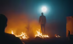 the man is looking at the blazing flame