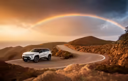 a car parked on the side of a road under a rainbow