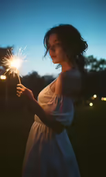 a woman holding a sparkler in her hands