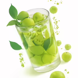 a glass filled with green apples with leaves floating in it