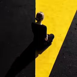 a young woman sitting on the ground with her skateboard in front of her