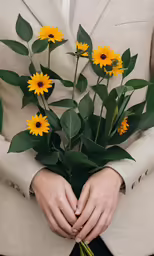 a man in a tan suit is holding a bouquet of yellow flowers