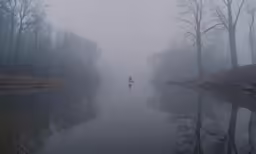 foggy lake with person in boat with oar