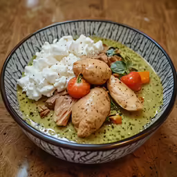 a green soup with vegetables and mashed potatoes