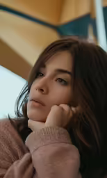 the young woman is posing with her hand to her head