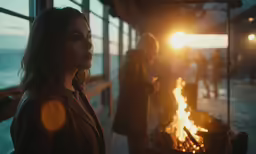 a woman is standing outside by the fire pit