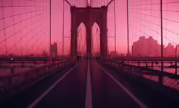 a pink colored sunset is reflected in the glass of the bridge