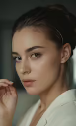 the girl is wearing a white shirt and has her hair in up