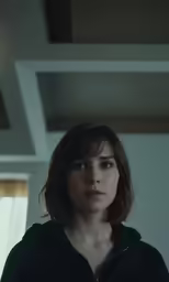a woman in black hoodie looking straight ahead