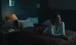 a woman sitting on a bed in the middle of the room