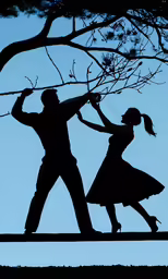 a silhouette shows a man and woman dancing next to a tree