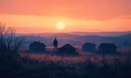 a silhouetted person stands among the silhouettes of huts