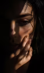 a woman with dark makeup looking down