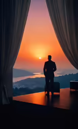 a person looking out a window as the sun sets