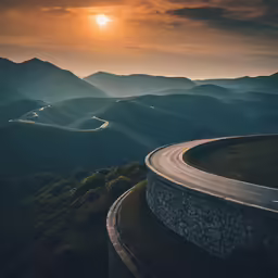a winding road surrounded by mountains under a bright sky