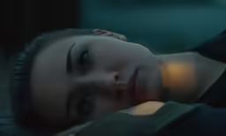 a girl looks at the camera and holds her hand on her head