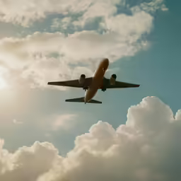the plane is flying above some clouds in a blue sky