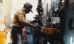 a man works on an industrial machine in a factory