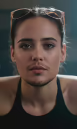 a young woman wearing sunglasses with her hair in pony tail