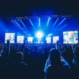 a person standing in front of a stage at night