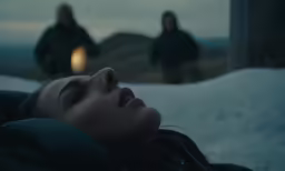 two people standing in the background and one laying down