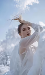 a young woman is posing with her hair flying over her head