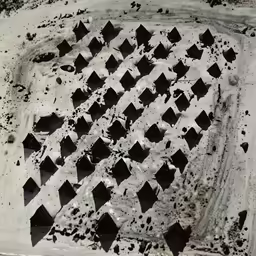 black and white photograph of a hole in a beach