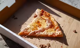 a piece of pizza is sitting inside of a box
