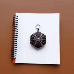 a note book and pen on top of a spiral bound paper